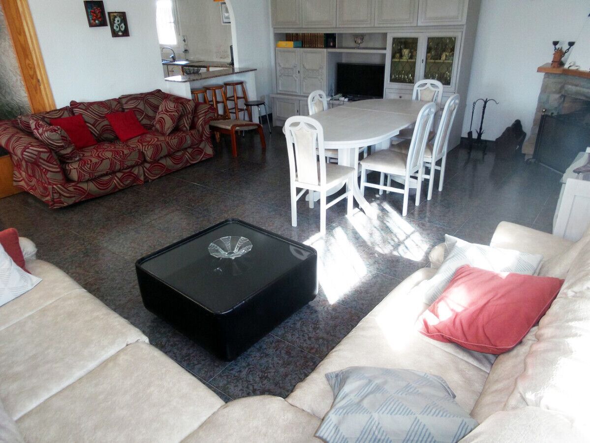 Un salon comprenant un canapé, une table basse et un coin repas avec des chaises et une table.