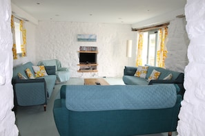 A living room with two sofas, a television, and a bookshelf.