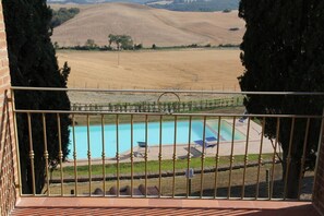 A pool with a view of a vineyard and hills.