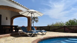 Un'area piscina con lettini e un ombrellone.
