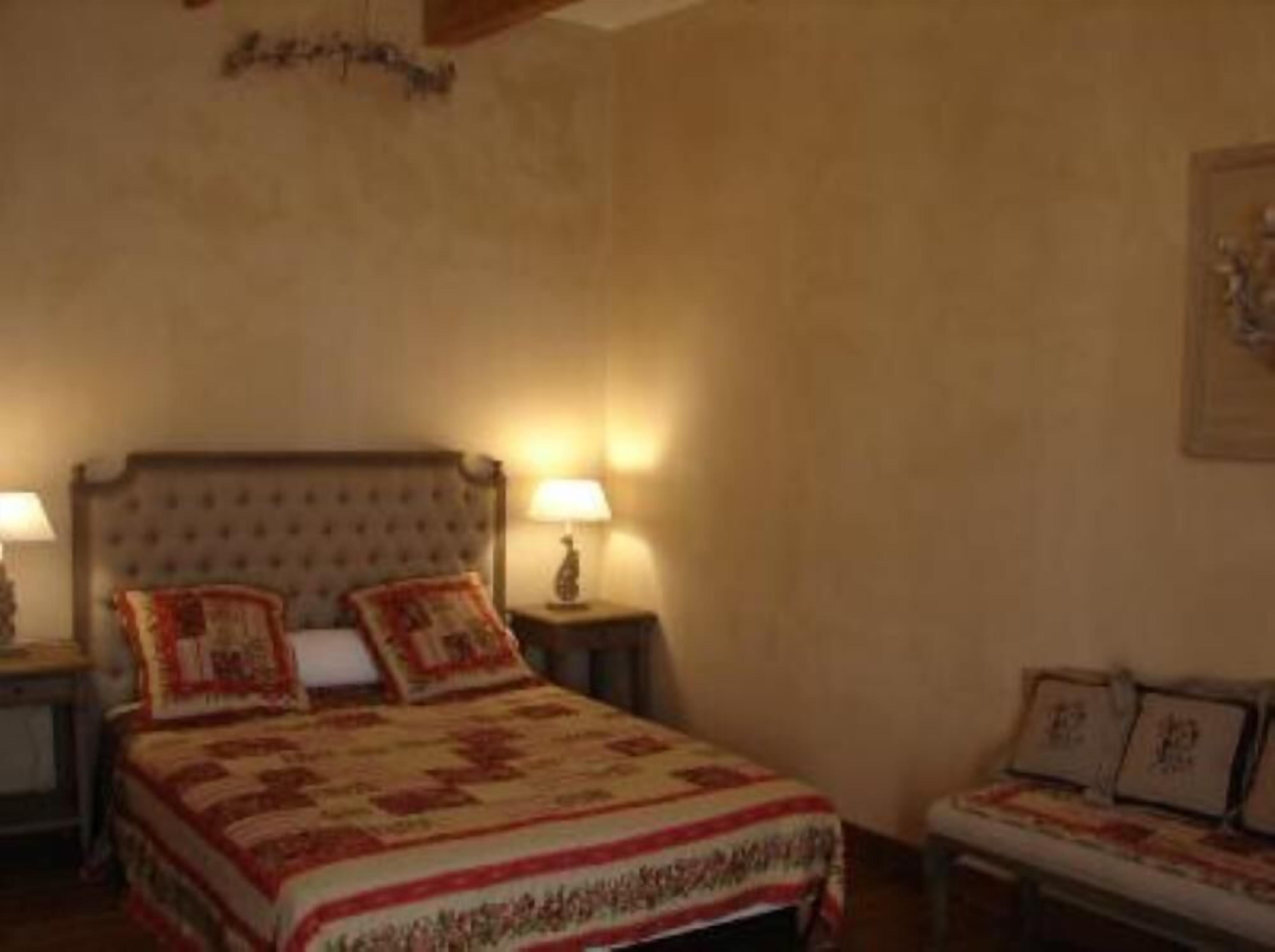A bedroom with a large bed, two bedside tables, and a wall-mounted lamp.