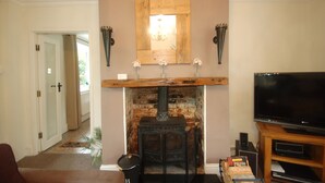 A living room with a fireplace, a television, and a wooden mantel. - Large Family Cottage With Hot Tub, Ideally Located For Activities. Pet Friendly. (Newark)