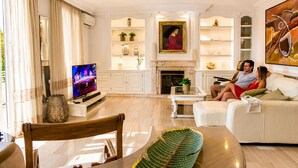 A living room with a TV, sofa, and a fireplace. - Villa in the City Center (Palma)