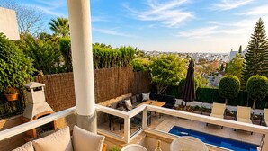 A terrace with a sofa, dining table, chairs, a pool, and a view of the city. - Villa in the City Center (Palma)