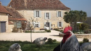 Un bâtiment en pierre avec un toit en tuiles et une cour intérieure.