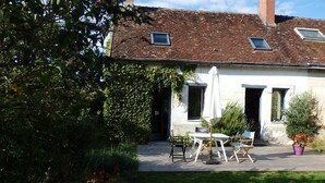 A house with a tiled roof, a garden, and outdoor seating. - In the heart of the Chateaux of the Loire (Saint-Georges-sur-Cher)