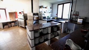 A modern kitchen with white cabinets, a granite countertop, and a central island with stacked plates.