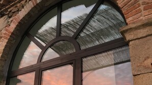 A large arched window with a view of a sunset. - L'Orangerie • Architect house -Private pool-Nature-Village view-Calm-Rivers.  (Joannas)