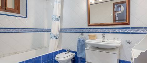 Un baño con inodoro, lavamanos y ducha.