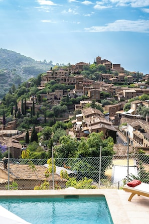 Una piscina con vistas a un pueblo en la ladera.