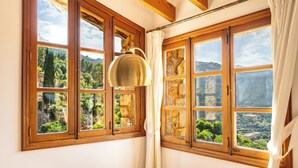 A room with large windows, wooden beams, and a hanging lamp. - SA VOLTA DE CA NóLIVER DEIA Villa with New Pool & Sea and Mountain Views (DEIA)