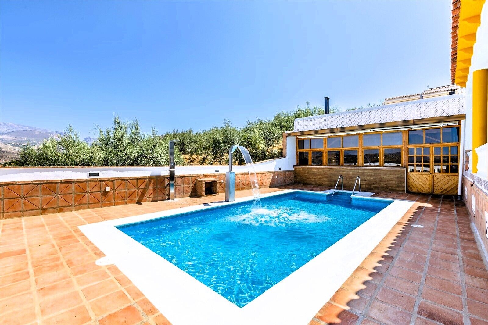 Una piscina en la azotea con vistas despejadas a las montañas al fondo.