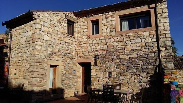 A stone building with a rustic exterior, featuring a small patio area with outdoor seating. - The Feng Shui House Perseverance for 4 people (Aldehuela)