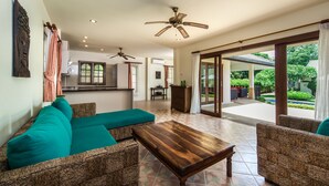 A spacious living area with wicker furniture, ceiling fans, and a view of the outdoor patio. - Deluxe 3 bed room pool villa in beach resort Idyllic Samui (Ko Samui)