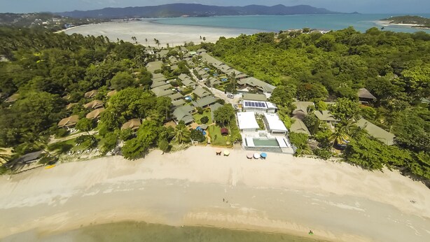 An aerial view of a resort with multiple bungalow-style buildings, a swimming pool, and a beach. - Deluxe 3 bed room pool villa in beach resort Idyllic Samui (Ko Samui)