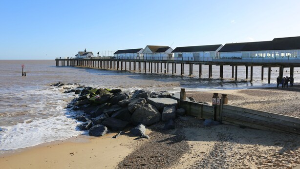 A pier extending into the sea with buildings on it.