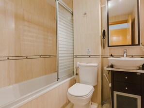 Ein Badezimmer mit Toilette, Waschbecken und Spiegel.