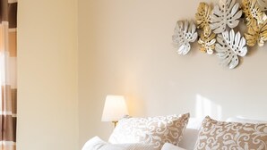 A hotel room with a bed, pillows, a lamp, and decorative wall art. - Beautiful apartment near the beach (Rincón de la Victoria)