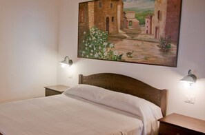 Cozy retreat with a single bed, bedside tables, and a beautiful framed painting.