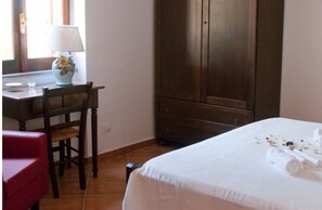 Relax in a classic room with a comfortable bed, desk, and chair.