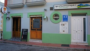 A building with a green and white facade, a sign for 'Alhambra La Seca', and a door labeled 'AT'. - Comfortable apartment within walking distance of Almería (Alhama de Almería)