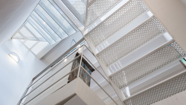 A modern interior with a staircase and a ceiling with a geometric pattern. - Sa Caseta. (Sóller)