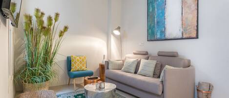 Un salon avec un canapé, une table basse, une lampe et un tableau au mur.