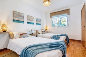 A bedroom with two beds, a window with blinds, and artwork on the wall. - VillaSense Luxury | Golf, Pool & Nature | Seville (Guillena)