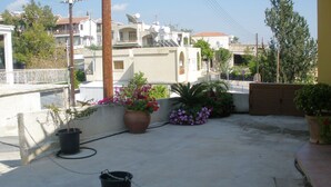 A rooftop terrace with potted plants, a water tank, and a gated entrance. - Private development of 12 Apartments in center of Peyia. Near to Coral Bay. (Peyia)