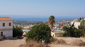 A coastal town with buildings, a palm tree, and a view of the sea. - Private development of 12 Apartments in center of Peyia. Near to Coral Bay. (Peyia)