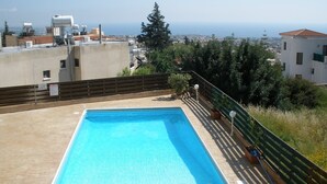 A rooftop pool with a clear view of the city and ocean in the background. - Private development of 12 Apartments in center of Peyia. Near to Coral Bay. (Peyia)