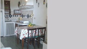 Una cucina funzionale con tavolo, sedie, forno a microonde e lavello.