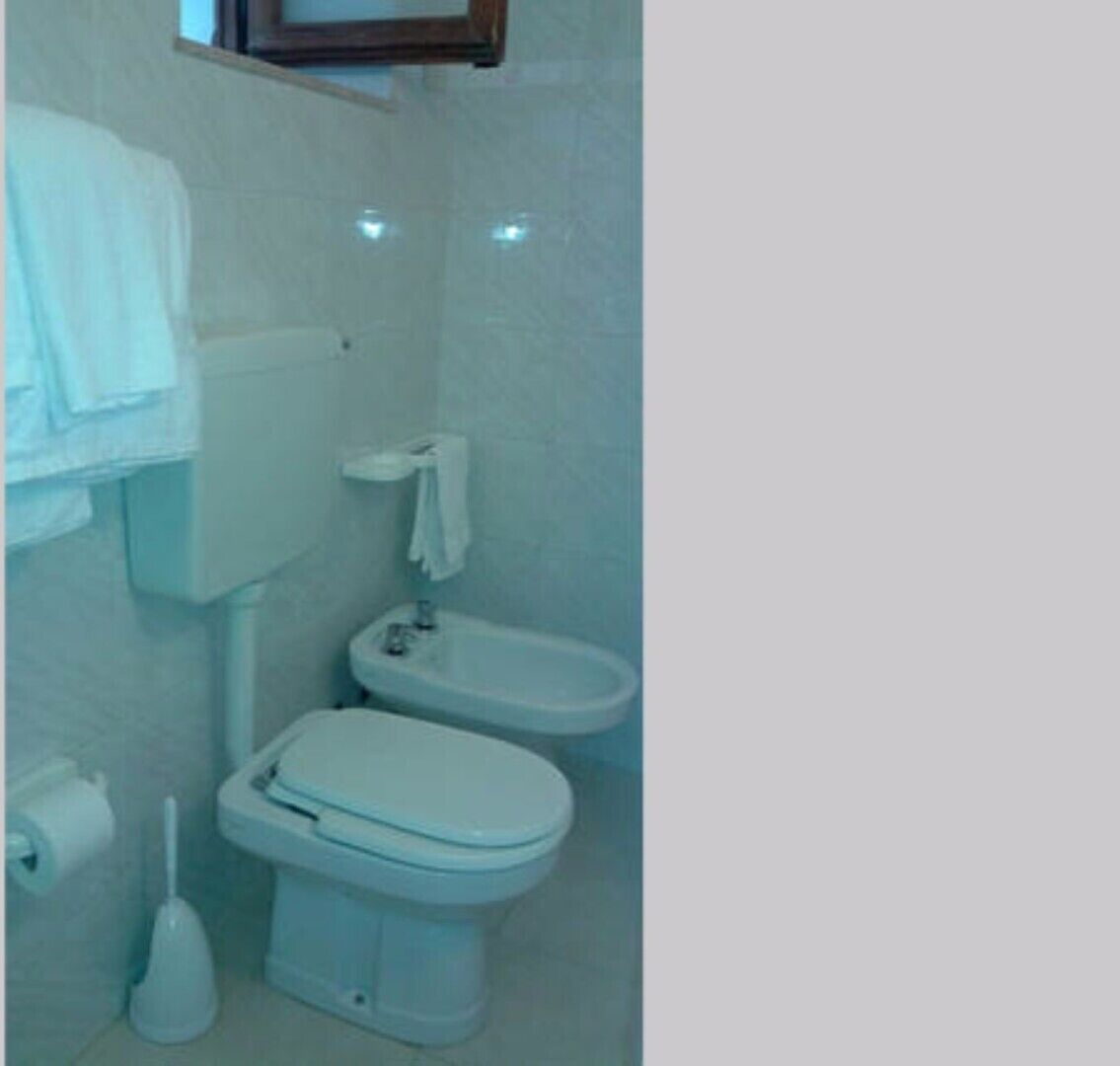 Ein kleines Badezimmer mit Toilette, Bidet und Waschbecken.