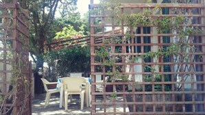 Un'area patio con recinto in legno, un tavolo e due sedie.