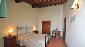 A bedroom with a bed, nightstands, a wardrobe, a desk with a chair, and a television. - CAMERA PENDOLINO at Agriturismo MUSIGNANO (cerreto, guidi)