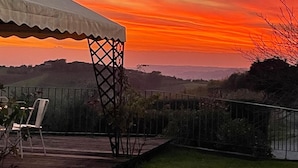 A patio with a white canopy, a basketball hoop, and a view of the countryside. - CAMERA PENDOLINO at Agriturismo MUSIGNANO (cerreto, guidi)