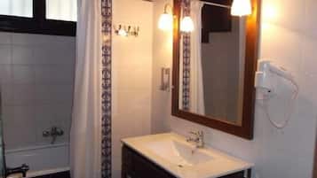 Een bad/douchecombinatie, een haardroger, handdoeken, shampoo