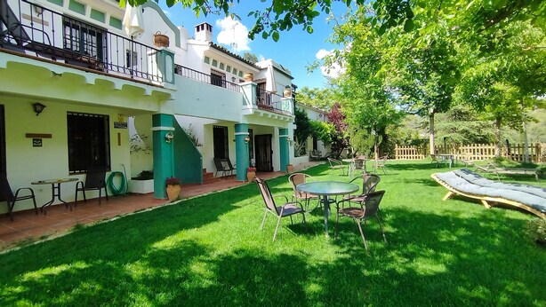 A courtyard with a lawn, outdoor seating, and a pool. - Rural apartment Aptos. Rural Tourism Las Maravillas for 5 people (Jaén)
