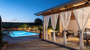 A pool area with a covered patio, outdoor seating, and potted plants. - Villa Green Oasis by AdriaticLuxuryVillas (Debeljak)