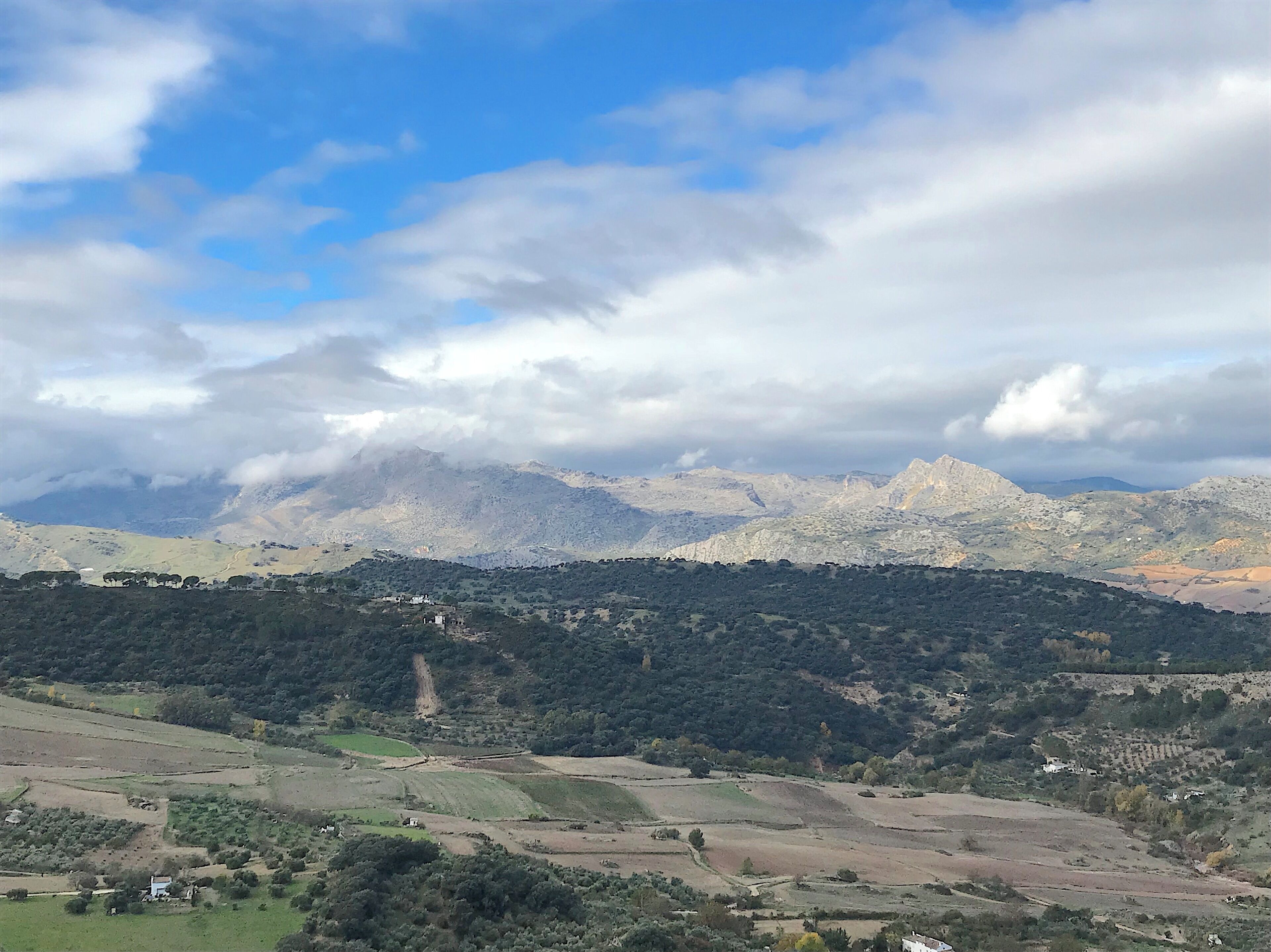 A mountainous landscape with scattered buildings and fields.