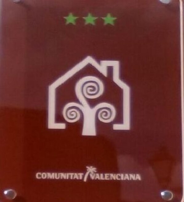 Ein Logo mit einem stilisierten Haus und einer Wirbelschleife, darunter der Text "COMUNITAT VALENCIANA".