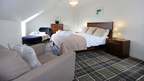 Une chambre d’hôtel avec un lit, un canapé, un bureau et une chaise.
