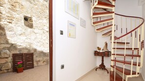 A staircase with wooden railings and a stone wall. - Apartment Nikolina house in center of the old town Trogir (Trogir)