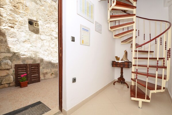 A staircase with wooden railings and a stone wall.