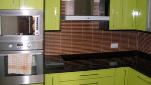 A kitchen with green cabinets, a microwave, and a stove. - Magnificent Penthouse in Barbate (Barbate)