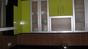A kitchen with green cabinets, a stainless steel range hood, and a tiled backsplash. - Magnificent Penthouse in Barbate (Barbate)