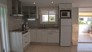 Een moderne keuken met witte kastjes, een roestvrijstalen afzuigkap, een magnetron en een ingebouwde oven.