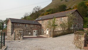 Ein Steinhaus mit Kiesweg und Holzzaun.