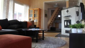 A cozy living room with a sofa, a coffee table, and a fireplace.