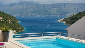 Ein Pool mit Blick auf eine Küstenstadt und Berge.